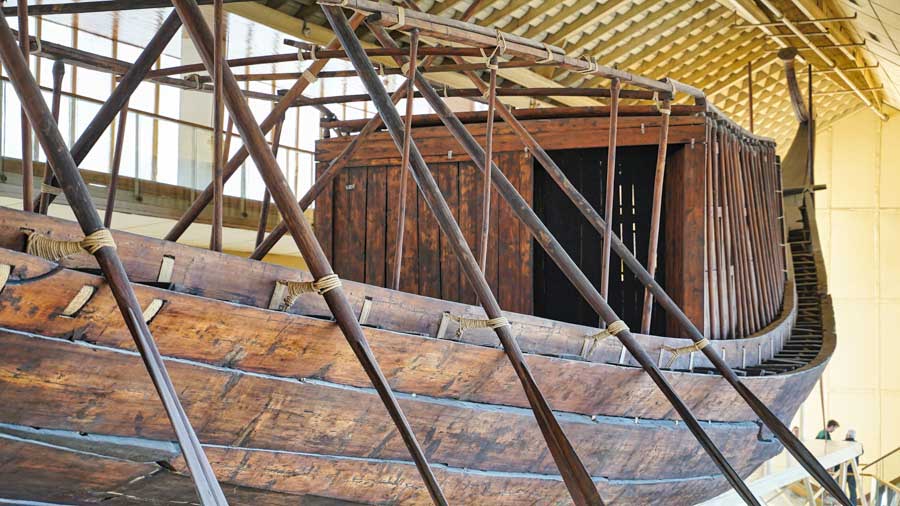 The reconstructed Great Solar Boat of Khufu — Old Kingdom cedar, built for oars — beside the Great Pyramid at Giza.
