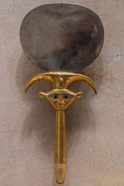 An Egyptian hand mirror: a polished metal disk set into a shaped handle.