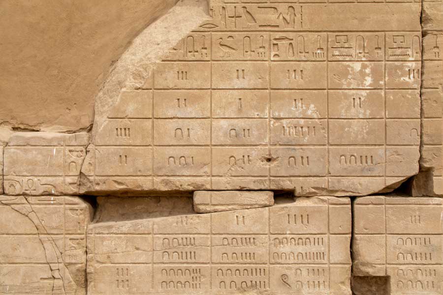 Hieroglyphic numerals carved on a stone wall in the Karnak temple complex, Luxor.